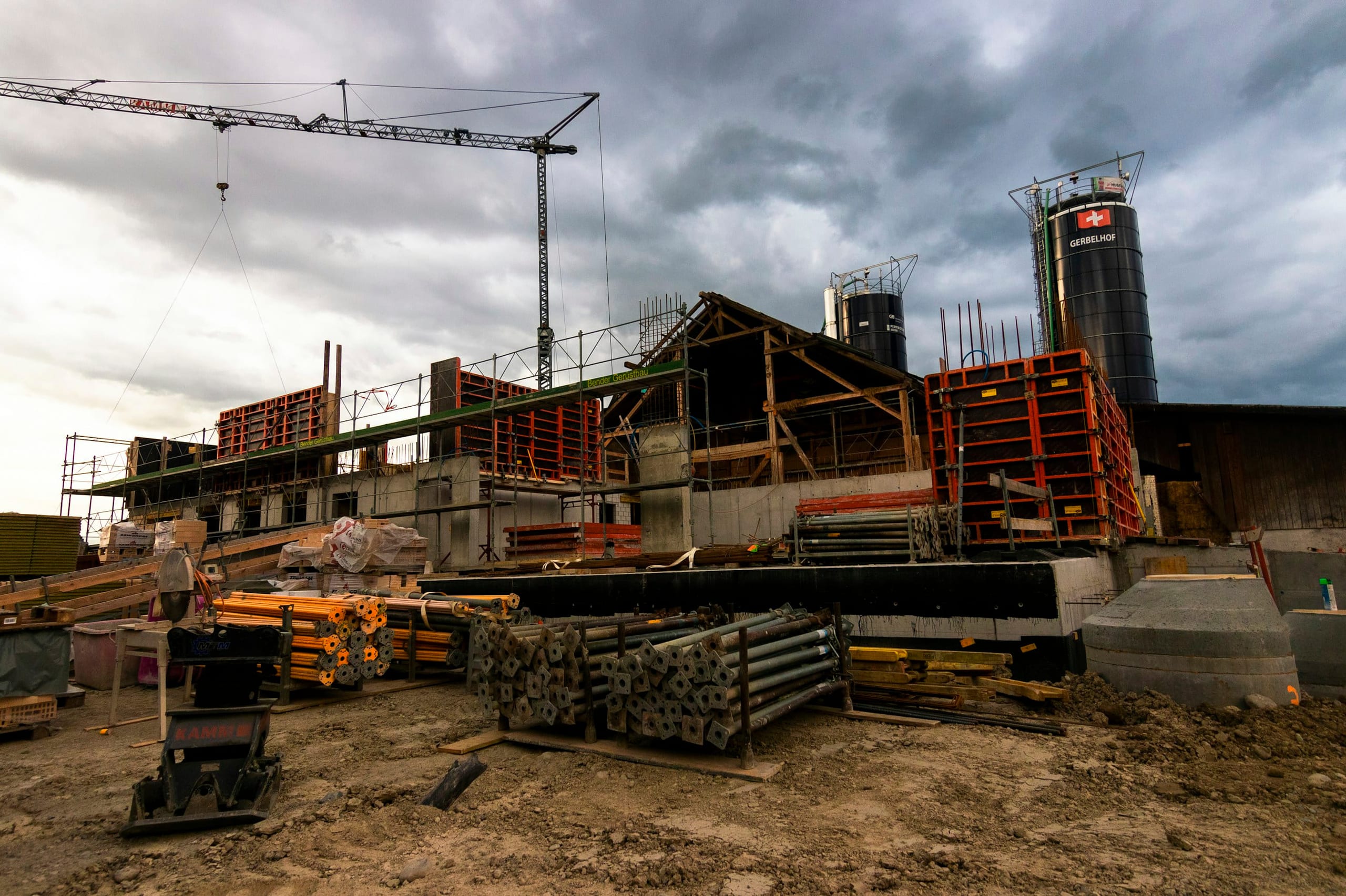 Baustelle mit gestapelten Schalungselementen und Baukran